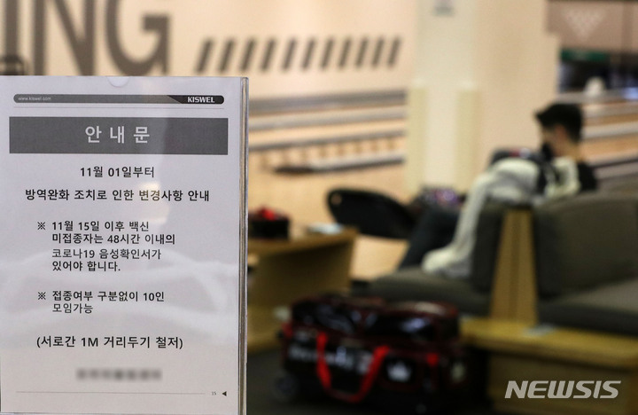[서울=뉴시스] 백동현 기자 = 지난 1일 단계적 일상회복(위드 코로나)로 방역체계를 전환하면서 목욕탕과 노래연습장, 실내체육시설 등 일부 고위험 시설에는 접종 완료자와 음성 판정을 받은 사람만 출입이 허용되는 가운데 제도 안착을 위해 1~2주일 계도기간을 정한 것을 두고 해당 시설 관리자와 이용자 모두 혼선을 빚고 있다. 이에 대해 방역당국은 "벌칙이나 행정처분을 부과하지 않는 것이지, 제도 자체를 시행하지 않는게 아니다."라며 "접종증명·음성확인제에 따라 증빙을 받고 출입해야 한다."고 밝혔다. 사진은 2일 오후 서울 시내 볼링장에 관련된 안내문이 놓여있는 모습. 2021.11.02. livertrent@newsis.com