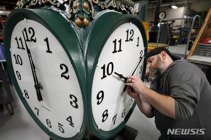 [메드필드=AP/뉴시스] 미국에서 오는 9일(현지 시간)부터 일광절약시간제(일명 서머타임제)가 시행돼 한국과의 시차가 1시간 줄어든다. 사진은 미 매사추세츠주 메드필드에서 한 시계회사 기술자가 대형 옥외 시계의 바늘을 조정하는 모습. 2025.3.7