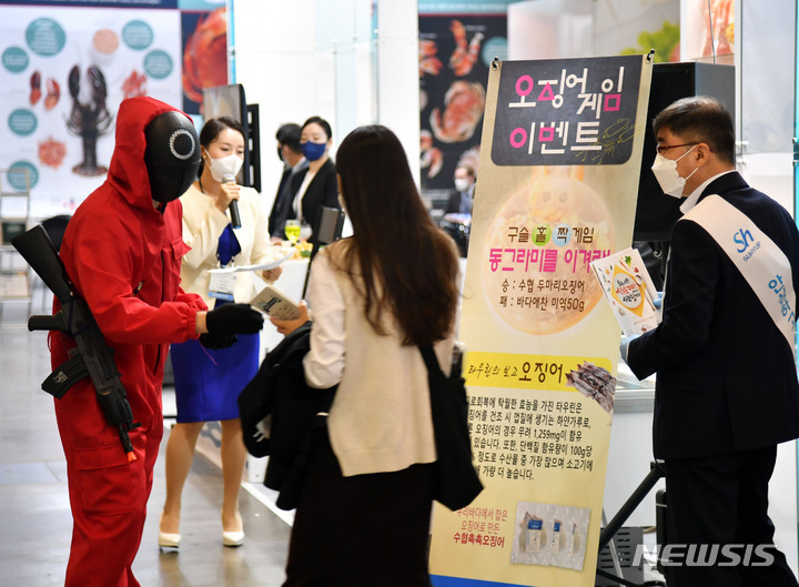 [부산=뉴시스] 하경민 기자 = 제19회 부산국제수산엑스포가 개막한 3일 오전 부산 벡스코 제1전시장 수협 관계들이 관람객을 대상으로 '오징어게임'에서 나온 홀짝 게임을 진행해 경품을 나눠주고 있다. 오는 5일까지 열리는 이번 엑스포에는 수산 관련 업체 343곳이 참가했다. 2021.11.03. yulnetphoto@newsis.com