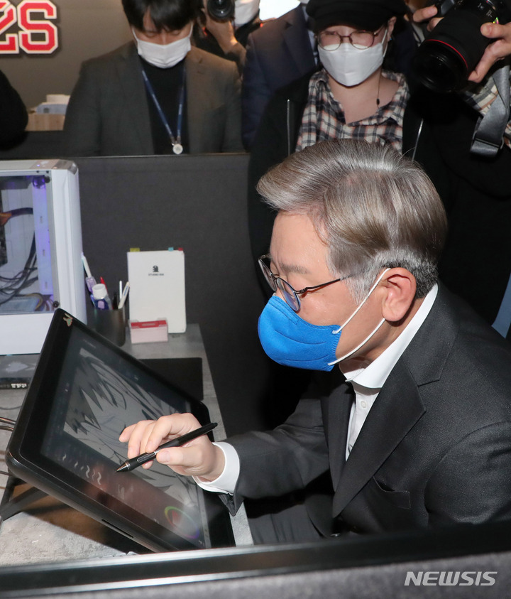 [부천=뉴시스] 국회사진기자단 = 이재명 더불어민주당 대선 후보가 3일 경기 부천테크노밸리U1센터에서 웹툰 작가들과 간담회 전 웹툰 작업 체험을 하고 있다. 2021.11.03. photo@newsis.com