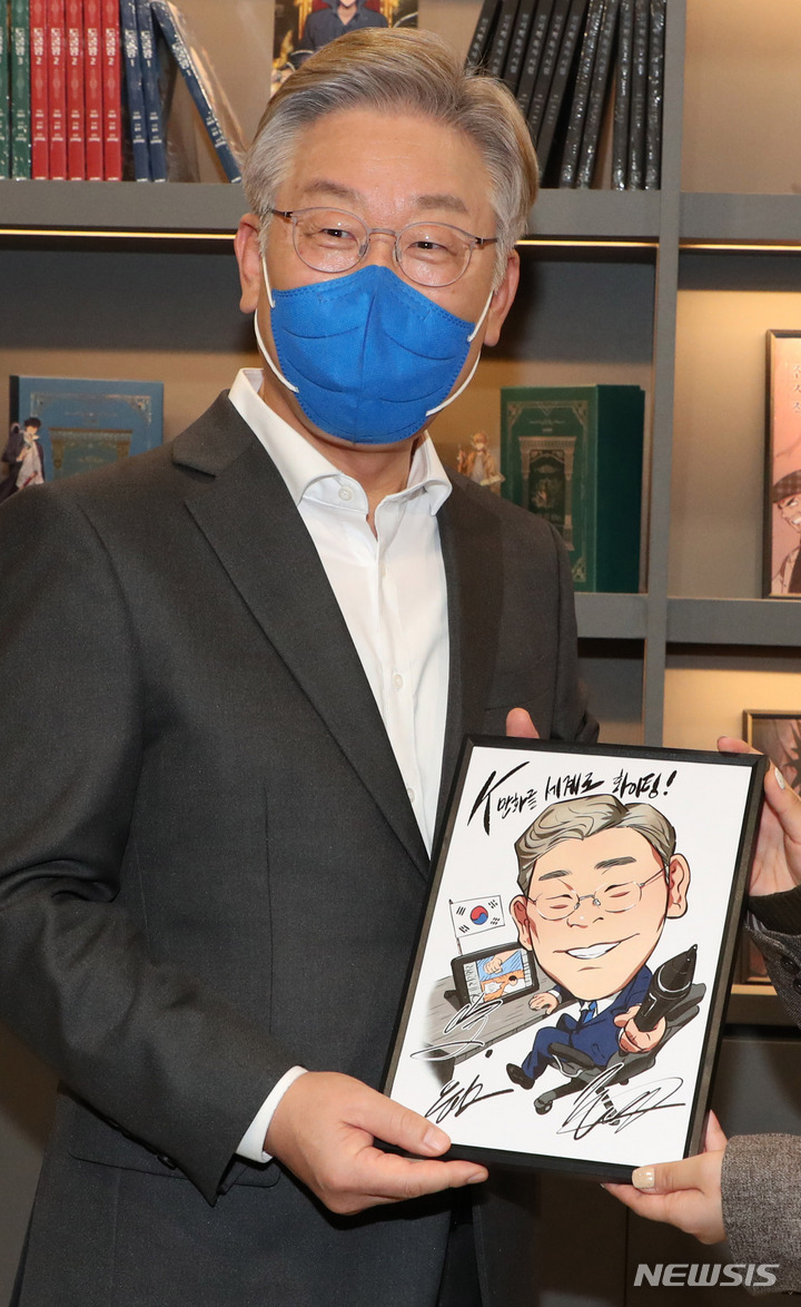 [부천=뉴시스] 국회사진기자단 = 이재명 더불어민주당 대선 후보가 3일 경기 부천테크노밸리U1센터에서 웹툰 작가들과 간담회 전 캐리커쳐 선물을 받고 있다. 2021.11.03. photo@newsis.com
