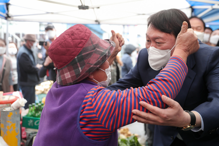 [서울=뉴시스] 전신 기자 = 윤석열 국민의힘 대선 경선 후보가 4일 오후 경기도 포천 송우시장을 방문해 한 상인과 인사하고 있다. (사진=윤석열 캠프 제공) 2021.11.04. photo@newsis.com *재판매 및 DB 금지