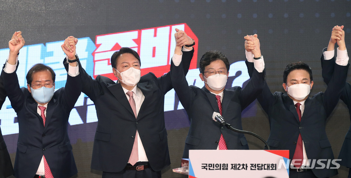 [서울=뉴시스] 전신 기자 = 국민의힘 대선 후보로 선출된 윤석열 후보가 5일 서울 용산구 백범김구기념관에서 열린 국민의힘 전당대회에서 손을 들어 인사하고 있다. 왼쪽부터 홍준표 경선 후보, 윤 후보, 유승민 경선 후보, 원희룡 경선 후보. 2021.11.05. photo1006@newsis.com
