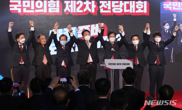 [서울=뉴시스] 전신 기자 = 국민의힘 대선 후보로 선출된 윤석열 후보가 5일 서울 용산구 백범김구기념관에서 열린 국민의힘 전당대회에서 손을 들어 인사하고 있다. 왼쪽부터 김기현 원내대표, 정홍원 선거관리위원장, 홍준표 후보, 윤 후보, 유승민 후보, 원희룡 후보, 이준석 대표. 2021.11.05. photo1006@newsis.com