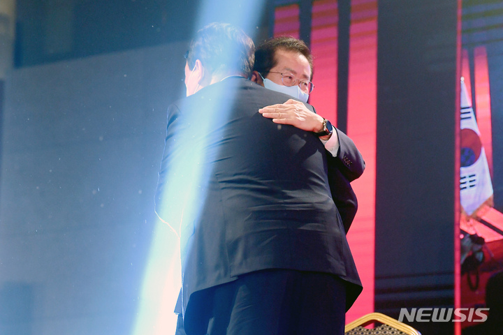 [서울=뉴시스] 최진석 기자 = 국민의힘 제20대 대통령 선거 후보에 선출된 윤석열 전 검찰총장이 5일 오후 서울 용산구 백범김구기념관에서 열린 제2차 전당대회에서 개표결과 발표 후 홍준표 후보와 포옹을 나누고 있다. (공동취재사진) 2021.11.05. photo@newsis.com