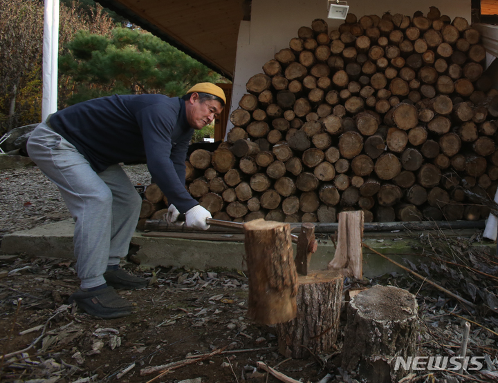 [평창=뉴시스] 김경목 기자 = 겨울이 시작된다는 입동을 하루 앞둔 6일 오후 강원도 평창군 산촌 마을의 주민이 땔감을 쓰기 위해 도끼로 장작을 패고 있다. 2021.11.07. photo31@newsis.com