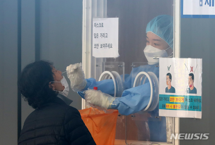 [서울=뉴시스] 배훈식 기자 = 단계적 일상회복(위드 코로나) 1단계 시행 뒤 첫 휴일인 7일 오전 서울 중구 서울역 광장에 마련된 코로나19 임시선별검사소에서 한 시민이 검사를 받고 있다. 2021.11.07. dahora83@newsis.com