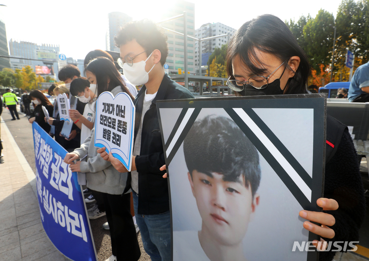 [서울=뉴시스] 배훈식 기자 = 민주노총 특성화고노조 등 학교부터 노동교육 운동본부 회원들이 7일 오후 서울 중구 서울시청 앞에서 기자회견을 열고 故 홍정운 군을 추모하며 묵념하고 있다. 2021.11.07. dahora83@newsis.com