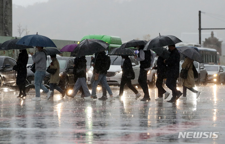 [서울=뉴시스] 박미소 기자 = 강풍을 동반한 비가 내리는 지난 8일 오전 서울 종로구 광화문 네거리에서 시민들이 우산을 쓰고 걸어가고 있다. 2021.11.08. misocamera@newsis.com