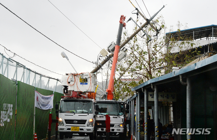 [전주=뉴시스] 김얼 기자 = 지난해 11월8일 전북 전주시 전주남부시장 인근의 전봇대가 기울어져 관계자들이 복구작업을 하고 있다. 2021.11.08. pmkeul@newsis.com