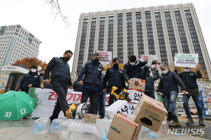 [서울=뉴시스] 김명원 기자 = 전국건설노동조합 노조원들이 9일 오전 서울 종로구 정부서울청사 앞에서 열린 건설기계 요소수 문제 정부 대책 촉구 기자회견에서 요소수와 건설기계장비 모형을 발로차는 퍼포먼스를 하고 있다. 2021.11.09. kmx1105@newsis.com