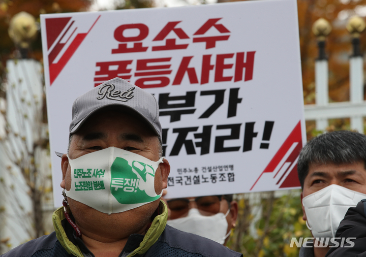 [서울=뉴시스] 김명원 기자 = 전국건설노동조합 노조원들이 9일 오전 서울 종로구 정부서울청사 앞에서 건설기계 요소수 문제 정부 대책 촉구 기자회견을 하고 있다. 2021.11.09. kmx1105@newsis.com