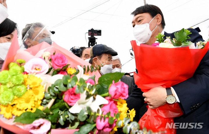 [화순=뉴시스] 변재훈 기자 = 국민의힘 윤석열 대선 후보가 10일 오전 전남 화순군 도곡면 고(故) 홍남순 변호사 생가를 방문해 지지자들로부터 꽃다발을 받고 있다. 고 홍 변호사는 양심수 변론을 도맡는 인권변호사로 활동했으며 5·18민주화운동 진상규명과 명예회복에 앞장섰다. 2021.11.10. wisdom21@newsis.com