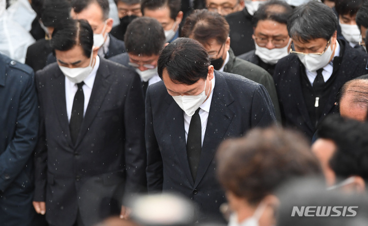 [광주=뉴시스] 류형근 기자 = 10일 오후 광주 북구 5·18 민주묘역을 찾은 국민의힘 윤석열 대선 후보가 방문을 반대하는 시민들에 막혀 묘역 근처에서 묵념을 하고 있다. (공동취재사진) 2021.11.10. photo@newsis.com