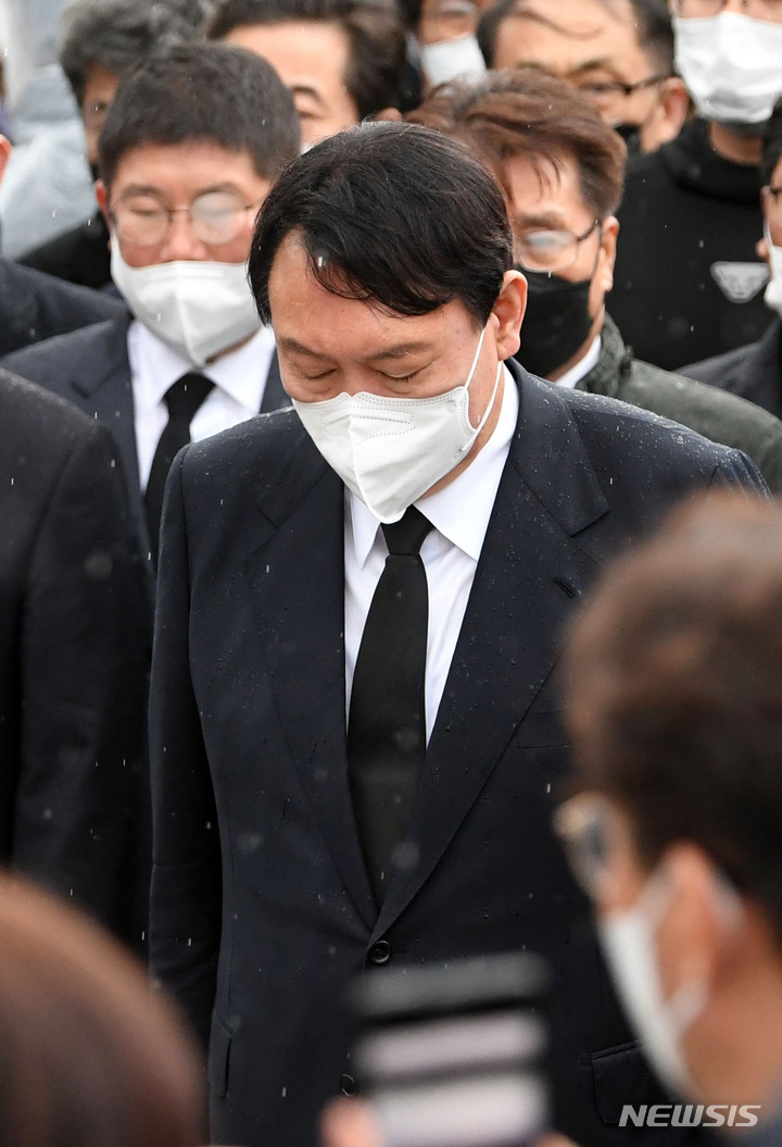 [광주=뉴시스] 류형근 기자 = 10일 오후 광주 북구 5·18 민주묘역을 찾은 국민의힘 윤석열 대선 후보가 방문을 반대하는 시민들에 막혀 묘역 근처에서 묵념을 하고 있다. (공동취재사진) 2021.11.10. photo@newsis.com