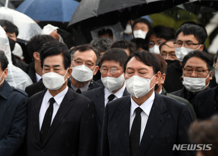 [광주=뉴시스] 류형근 기자 = 10일 오후 광주 북구 5·18 민주묘역을 찾은 국민의힘 윤석열 대선 후보가 방문을 반대하는 시민들에 막혀 묘역 근처에서 묵념을 하고 있다. (공동취재사진) 2021.11.10. photo@newsis.com