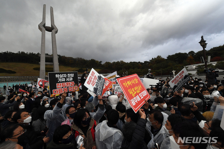 [광주=뉴시스] 류형근 기자 = 10일 광주 북구 5·18 민주묘역을 찾은 국민의힘 윤석열 후보의 방문을 반대하는 시민들이 피켓을 들고있다. (공동취재사진) 2021.11.10. photo@newsis.com