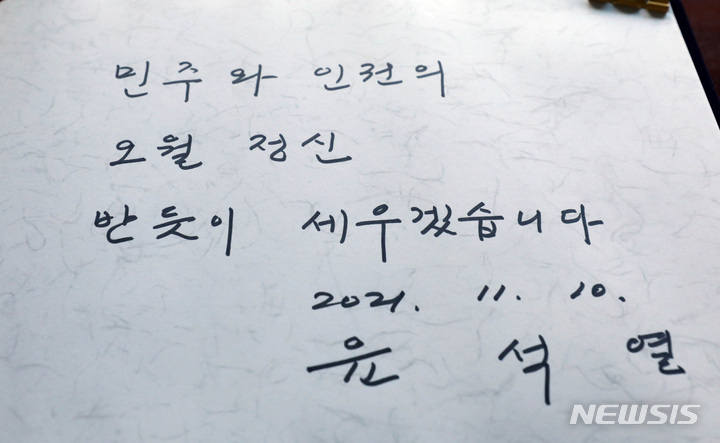 [광주=뉴시스] 류형근 기자 = 국민의힘 윤석열 대선후보가 10일 광주 북구 국립 5·18 민주묘지를 참배하기에 앞서 방명록을 작성했다. (공동취재사진) 2021.11.10. photo@newsis.com