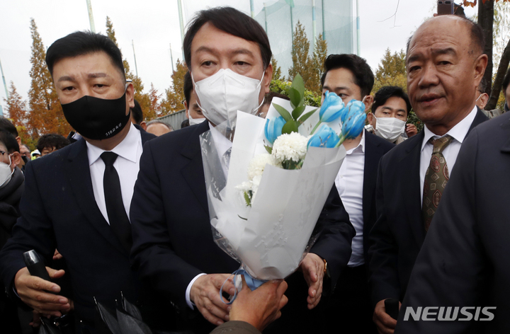 [광주=뉴시스] 류형근 기자 = 윤석열 국민의힘 대선후보가 1-일 오후 광주 서구 5·18자유공원을 찾은 가운데 지지자가 꽃다발을 전달하고 있다. 2021.11.10. hgryu77@newsis.com