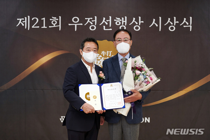 [서울=뉴시스] 코오롱그룹 오운문화재단은 11일 대구남산종합사회복지관에서 제 21회 우정선행상 대상 시상식을 개최했다. 23년간 장애인을 위해 휠체어를 수리하고 기증해온 ‘휠체어 천사’ 신동욱 씨(오른쪽)와 이웅열 오운문화재단 이사장이 기념촬영을 하고 있다. (사진=코오롱그룹 제공)