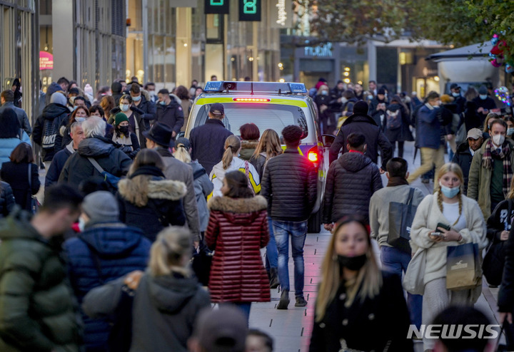 [프랑크푸르트=AP/뉴시스] 10일(현지시간) 독일 프랑크푸르트 쇼핑가에서 경찰차 한 대가 많은 시민 사이를 지나 순찰하고 있다. 2021.11.11