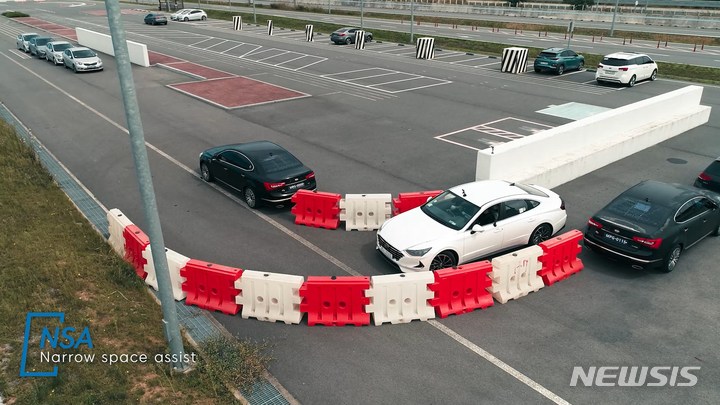 [서울=뉴시스] 현대모비스는 도심형 자율주행 신기술인 차세대 주차제어시스템(MPS)을 세계 최초로 개발했다고 14일 밝혔다. 협로주행, 후방자율주행, 원격 자동주차 등이 가능한 기술이다. 현대모비스 서산 주행시험장에서 연구원들이 관련 기술이 장착된 차량을 시험하고 있는 모습. (사진=현대모비스 제공)