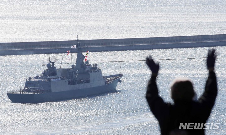 [부산=뉴시스] 하경민 기자 = 해군 청해부대 36진 '최영함'(DDH-Ⅱ·4400t급)이 12일 오전 부산 남구 해군작전사령부에서 출항한 가운데 부대 인근에서 한 부모가 손을 흔들며 환송하고 있다. '아덴만 여명작전'의 주역인 최영함은 이번 36진이 7번째 파병이다. 36진은 승조원을 비롯해 특수전(UDT)장병으로 구성된 검문검색대와 해상작전헬기를 운용하는 항공대 장병 등 300여 명으로 구성됐다. 이날 출항 환송식은 코로나19 확산 방지를 위해 가족 등 외부 인사 초청없이 진행됐다. 2021.11.12. yulnetphoto@newsis.com