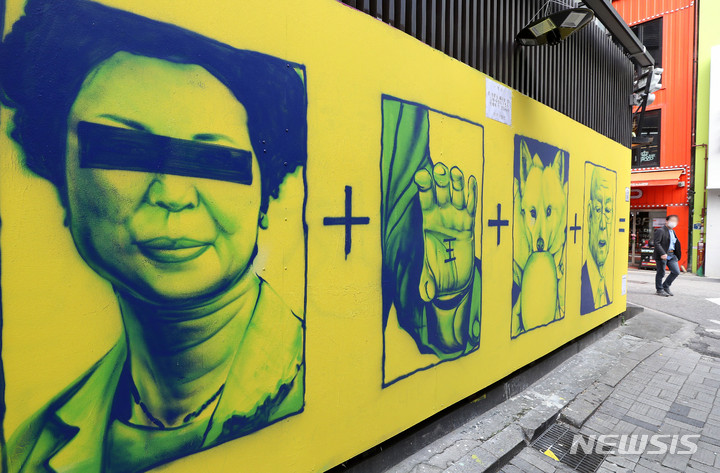 [서울=뉴시스] 백동현 기자 = 13일 오후 서울 종로구 한 중고서점 건물 외벽에 운석열 국민의힘 대선 후보와 관련한 벽화가 그려져 있다. 2021.11.13. livertrent@newsis.com