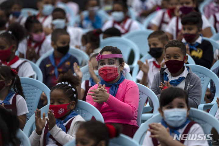 [아바나=AP/뉴시스] 15일(현지시간) 쿠바 아바나에서 열린 개학식에 참석한 어린이들이 마스크를 쓴 채 박수하고 있다. 쿠바는 이날 여행 금지 등 지난 20개월간의 엄격한 봉쇄를 해제했다. 2021.11.16.