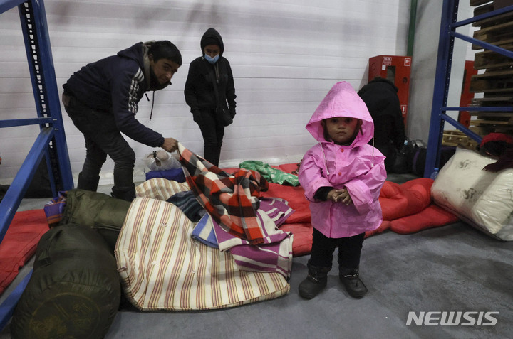 [쿠즈니차=AP/뉴시스]16일(현지시간) 벨라루스 그로드노 인근 벨라루스-폴란드 국경에 있는 쿠즈니차 국경검문소 물류센터에서 난민들이 입국하지 못한 채 혹한과 굶주림을 견디고 있다. 2021.11.17.