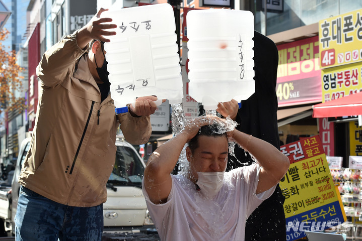 [대구=뉴시스] 이무열 기자 = 17일 오후 대구 중구 동성로 광장에서 행동하는 보수지지연대가 주최한 '기성 정치권의 부패와 구태를 규탄하는 집회'에 참가한 지역 청년들이 최근 이슈가 되고 있는 요소수 파동 등 현 정권의 무능을 비판하는 의미를 담아 요소수 통에 담긴 물을 몸에 붓는 퍼포먼스를 하고 있다. 2021.11.17. lmy@newsis.com