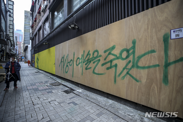 [서울=뉴시스] 정병혁 기자 = 17일 오후 서울 종로구에 위치한 한 중고서점 외벽에 그려져있던 윤석열 국민의힘 대선 후보와 관련된 벽화가 판자로 가려져있다. 가려진 판자엔 "세상이 예술을 죽였다"라고 써 있다. 2021.11.17. jhope@newsis.com