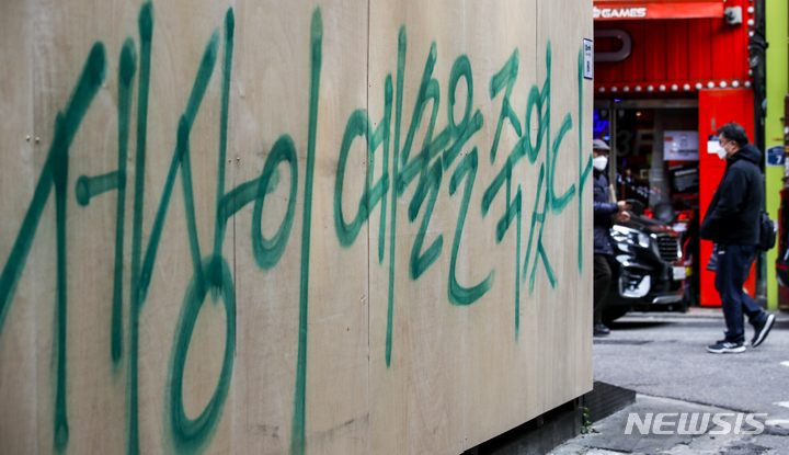 [서울=뉴시스] 정병혁 기자 = 17일 오후 서울 종로구에 위치한 한 중고서점 외벽에 그려져있던 윤석열 국민의힘 대선 후보와 관련된 벽화가 판자로 가려져있다. 가려진 판자엔 "세상이 예술을 죽였다"라고 써 있다. 2021.11.17. jhope@newsis.com