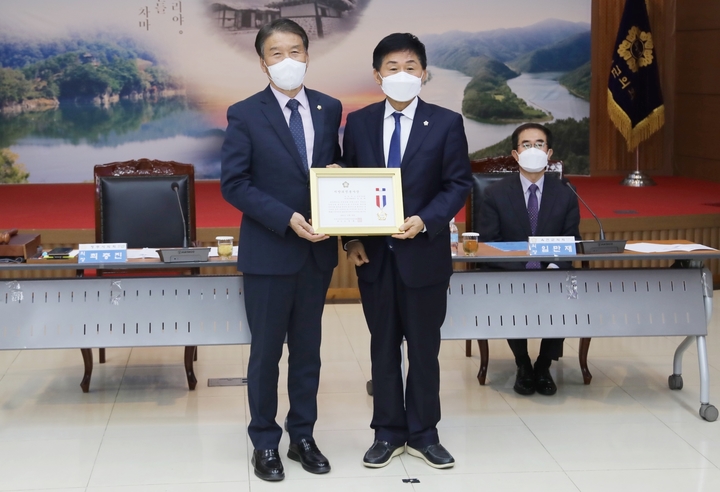 [증평=뉴시스] 강신욱 기자 = 충북 증평군의회 장천배(왼쪽) 의원이 18일 옥천군의회에서 열린 88차 충북 시·군의회의장협의회에서 최충진 협의회장으로부터 의정봉사상을 전수받고 있다. (사진=증평군의회 제공) 2021.11.18. photo@newsis.com *재판매 및 DB 금지
