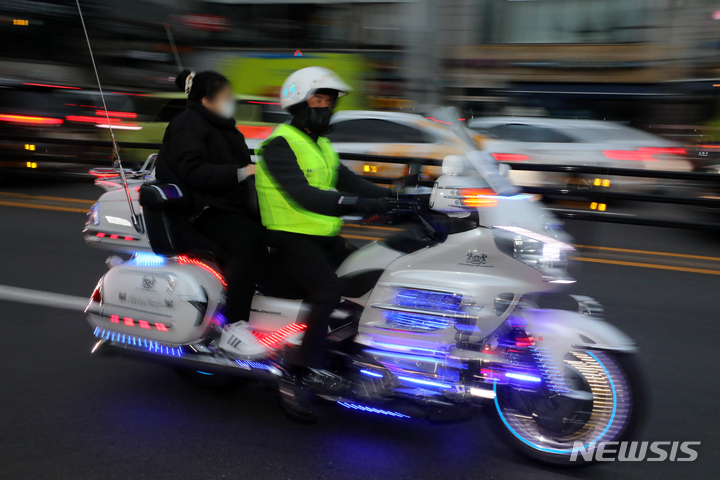 [서울=뉴시스] 배훈식 기자 = 2022학년도 대학수학능력시험이 치러진 18일 오전 서울 종로구 경복궁역 앞에서 한 수험생이 전국모터사이클동호회 모닝캄 회원들의 오토바이를 타고 시험장으로 향하고 있다. 2021.11.18. dahora83@newsis.com