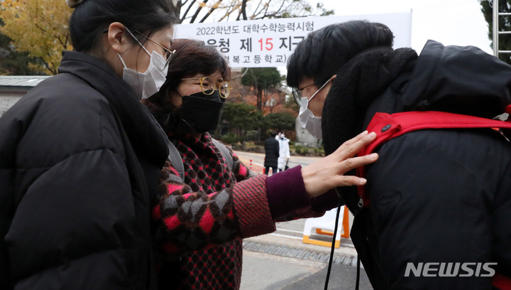 [서울=뉴시스] 추상철 기자 = 2022학년도 대학수학능력시험이 시행된 18일 오전 서울 종로구 경복고등학교에 마련된 서울시교육청 제15지구 제1시험장 앞에서 수험생이 어머니에게 인사하고 있다. 2021.11.18. scchoo@newsis.com