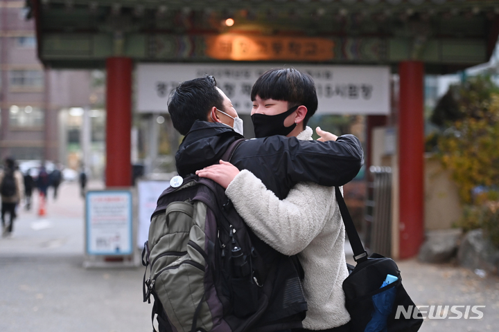 [수원=뉴시스] 김종택기자 = 2022학년도 대학수학능력시험이 치러진 18일 오전 경기도 수원시 영통구 태장고등학교 앞에서 한 학부모가 수험생을 안아주며 격려하고 있다. 2021.11.18.jtk@newsis.com