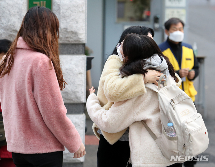 [서울=뉴시스] 조성우 기자 = 2022학년도 대학수학능력시험(수능)일인 18일 오전 서울 강남구 개포고등학교에서 수험생이 가족의 응원을 받으며 고사장으로 향하고 있다. 2021.11.18. xconfind@newsis.com