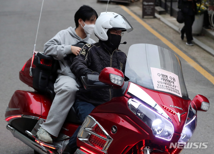 [서울=뉴시스] 추상철 기자 = 2022학년도 대학수학능력시험이 시행된 18일 오전 서울 종로구 경복고등학교에 마련된 서울시교육청 제15지구 제1시험장 앞에서 수험생이 수송 오토바이를 타고 도착하고 있다. 2021.11.18. scchoo@newsis.com