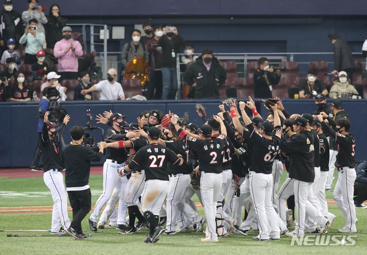 [서울=뉴시스] 조수정 기자 = 18일 오후 서울 구로구 고척스카이돔에서 열린 2021 KBO 한국시리즈 두산 베어스와 KT 위즈의 4차전 경기, 8-4로 최종 승리를 거둔 KT 선수들이 부상으로 목발을 짚고 나오다 바닥에 내려놓은 박경수(맨 왼쪽)와 기쁨을 나누고 있다. 2021.11.18. chocrystal@newsis.com