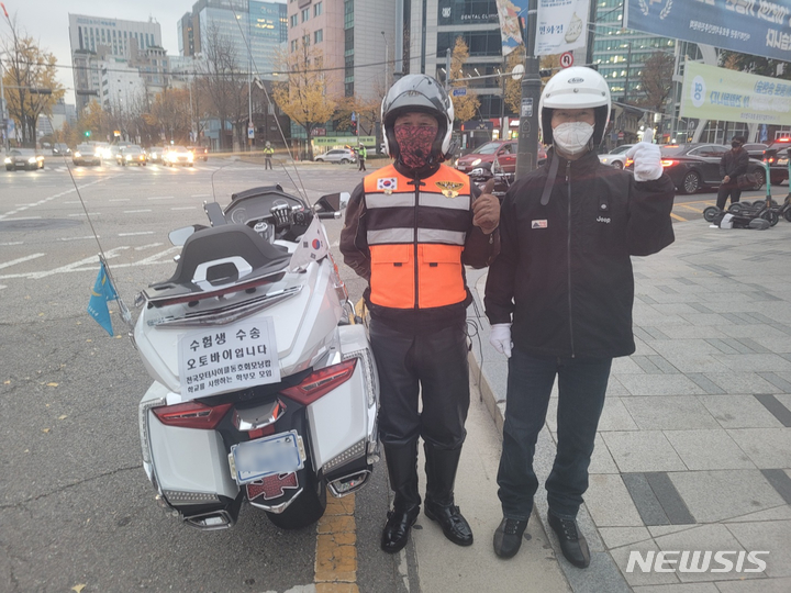 [서울=뉴시스]정유선기자=지난 18일 오전 안국역 사거리에서 모터사이클동호회 '모닝캄' 회원 윤석현(오른쪽)씨와 또 다른 회원이 수험생 수송 전 대기하며 포즈를 취하고 있다.