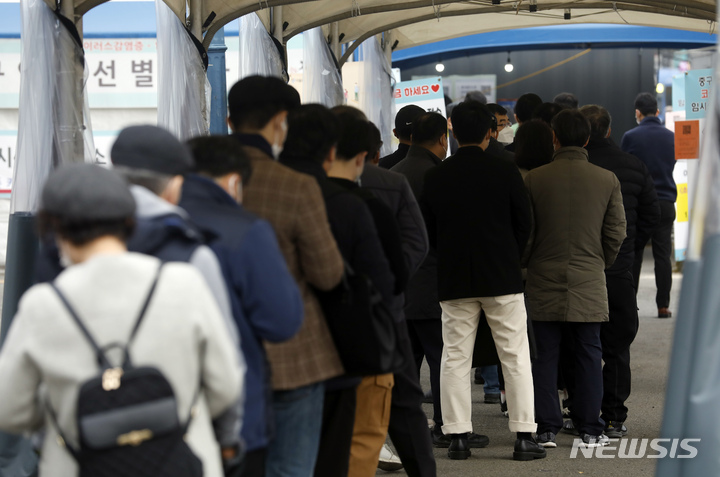 [서울=뉴시스] 고승민 기자 = 0시 기준 코로나19 신규 확진자가 3034명으로 사흘째 3000명대를 기록하고 있는 19일 서울역 코로나19 임시선별검사소를 찾은 시민이 검사를 기다리고 있다. 2021.11.19. kkssmm99@newsis.com
