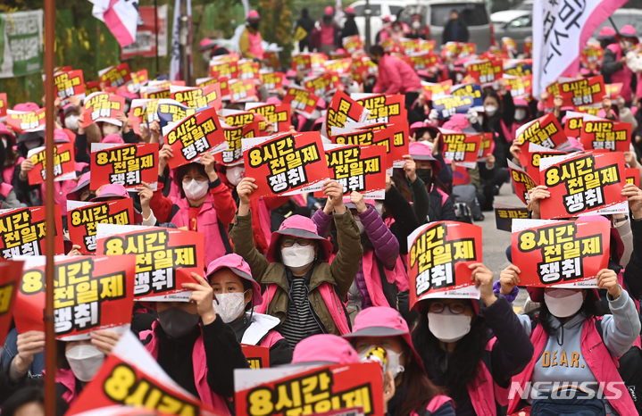 [수원=뉴시스] 김종택기자 = 경기지역 초등돌봄전담사들이 '8시간 전일제' 수용을 요구하며 총파업에 돌입한 19일 오후 경기도 수원시 장안구 경기도교육청 앞에서 구호를 외치고 있다. 앞서 교육부는 지난 8월 돌봄 운영시간을 현행 오후 5시에서 7시로 연장하고 이에 따른 돌봄전담사들의 근로시간 조정안 등의 내용이 담긴 초등 돌봄교실 운영 개선 방안을 발표했다. 2021.11.19. jtk@newsis.com