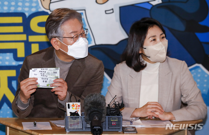 [보은=뉴시스] 정병혁 기자 = 이재명 더불어민주당 대선 후보와 부인 김혜경 씨가 21일 오전 충북 보은군 보은마루에서 열린 판동초등학교 학생들과 함께하는 국민반상회에서 팔판동사회적협동조합에서 발급하는 매점쿠폰을 살펴보고 있다. 2021.11.21. jhope@newsis.com