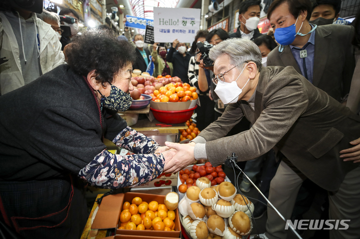 [청주=뉴시스] 정병혁 기자 = 이재명 더불어민주당 대선 후보와 부인 김혜경 씨가 21일 오후 충북 청주시 육거리종합시장을 찾아 과일을 구매하고 있다. 2021.11.21. jhope@newsis.com
