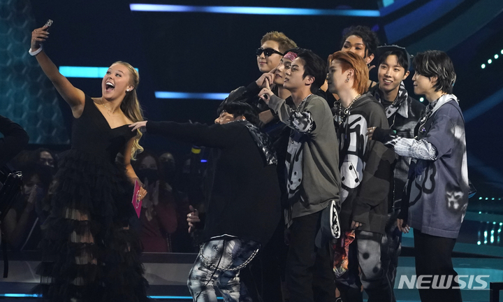 [로스앤젤레스=AP/뉴시스] 그룹 방탄소년단(BTS)이 21일(현지시간) 미 캘리포니아주 로스앤젤레스의 마이크로소프트 극장에서 열린 ‘아메리칸 뮤직 어워즈’(American Music Awards·AMA) ‘페이버릿 팝 듀오 오어 그룹’(Favorite Pop Duo or Group) 부문 수상 후 가수 조조 시와와 셀카를 찍고 있다. 2021.11.22.