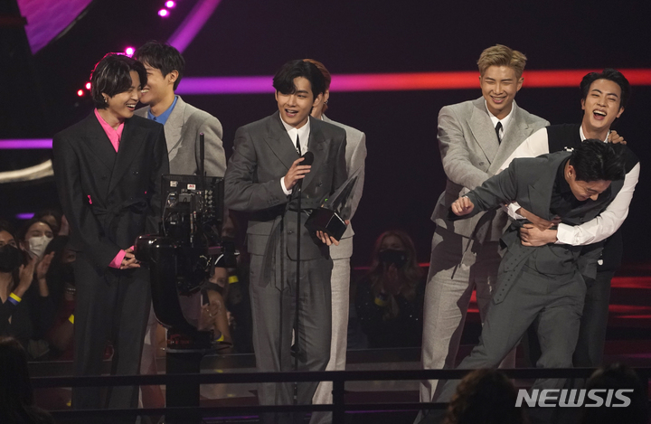 [로스앤젤레스=AP/뉴시스] 그룹 방탄소년단(BTS)이 21일(현지시간) 미 캘리포니아주 로스앤젤레스의 마이크로소프트 극장에서 열린 ‘아메리칸 뮤직 어워즈’(American Music Awards·AMA)에 참석해 '올해의 아티스트'상을 받고 있다. 2021.11.22.