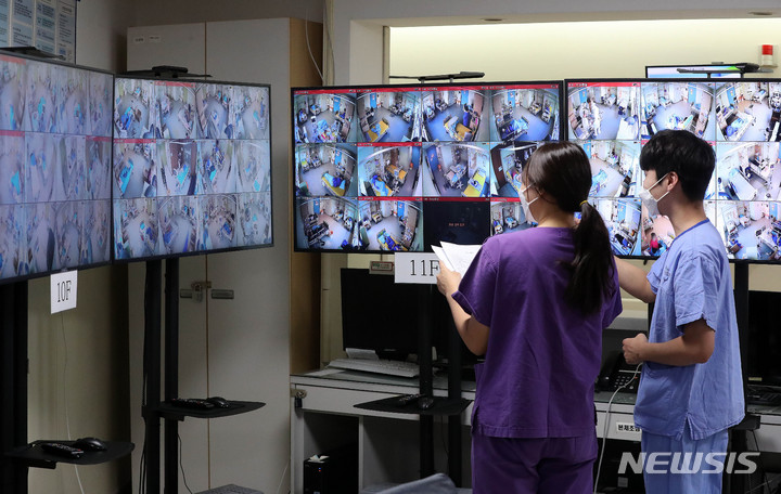 [서울=뉴시스] 백동현 기자 = 22일 오후 서울 중랑구 서울의료원 코로나19 종합상황실에서 의료진들이 병상 CCTV를 살펴보고 있다. 이날 보건복지부 중앙사고수습본부(중수본)에 따르면 현재 하루 이상 병상 대기자는 수도권만 총 907명이다. 비수도권 병상 대기자는 없다. 2021.11.22. livertrent@newsis.com