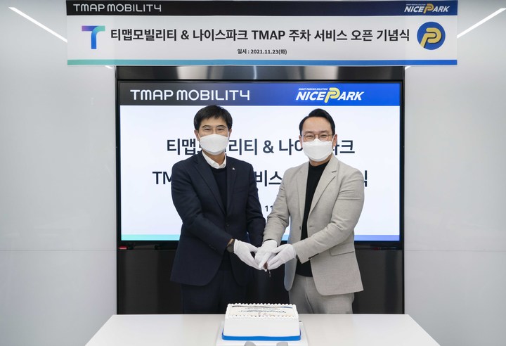 [서울=뉴시스]임훈택(왼쪽) 한국전자금융 주차사업본부장과 양성우 티맵모빌리티 MOD 담당이 서울 명동 티맵모빌리티 본사에서 티맵 주차 서비스 오픈을 기념해 케이크 커팅을 하고 있다. (사진=티맵모빌리티 제공) 2021.11.24