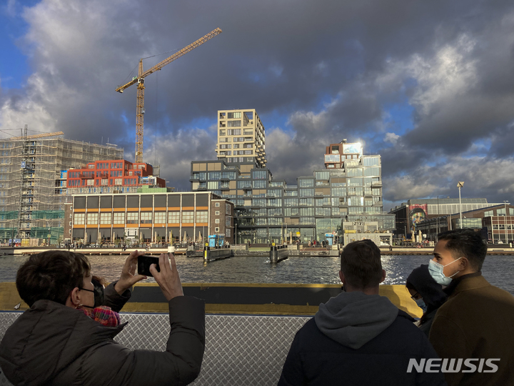 [암스테르담=AP/뉴시스] 지난 19일(현지시간) 네덜란드 암스테르담에서 일부 마스크를 착용한 통근자와 관광객들이 IJ 강을 건너 암스테르담 북부로 가는 무료 페리를 타고 있다. 네덜란드 정부는 23일 코로나19 감염자 수가 주간 최고 기록을 경신하고 병원과 중환자실 입원이 급증하면서 모든 성인에 대해 사회적 거리 두기를 다시 의무화한다고 발표했다. 2021.11.24.